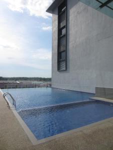 una piscina al lado de un edificio en D Hotel en Seri Iskandar