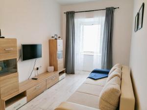 ein Wohnzimmer mit einem Sofa und einem TV in der Unterkunft Apartments Valiža in Senj