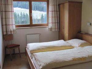 a bedroom with two beds and a window at An der Mühle in Tux