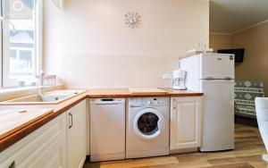 a kitchen with a white refrigerator and a washing machine at Apartament Pod 13 in Kowary