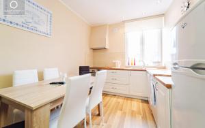 a kitchen with a wooden table and white appliances at Apartament Pod 13 in Kowary