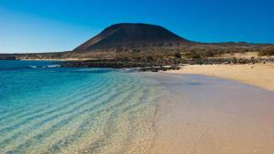 vistas a una playa con una montaña en el fondo en Apartamento las Crucetas, en Caleta de Sebo