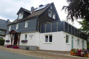 una gran casa blanca con techo negro en Pension Haus Butz, en Winterberg