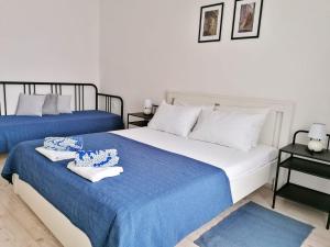 a bedroom with two beds with blue and white sheets at Apartments Valiža in Senj