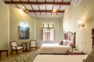 a bedroom with a bed and a table and chairs at Casa Tavera- Adults Only in Mérida