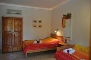 een slaapkamer met een bed met twee knuffels erop bij Lysistrata Bungalows in Potos