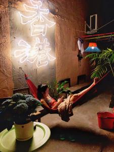 a woman laying in a hammock in a room at Wontonmeen in Hong Kong