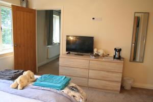 um quarto com um urso de peluche sentado numa cama em Labbadax House em Wisbech
