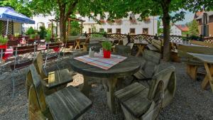 een houten tafel en stoelen in een patio met een tafel en stoelen bij Gasthof zur Post in Raisting