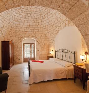 um quarto com uma cama grande numa parede de pedra em Masseria Madonna dell'Arco Agriturismo em Martina Franca