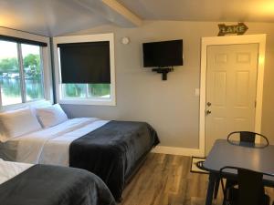 a bedroom with two beds and a tv and a window at Alexander's Landing in Monticello