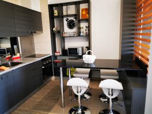 a kitchen with a black table and stools at Apartamento Jeni Residencia Flamingo in Portimão