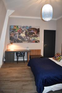 a bedroom with a bed and a desk with a painting on the wall at Hermitage Henry in Maresches