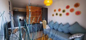 Apartamento Jeni Residencia Flamingo في بورتيماو: غرفة معيشة مع أريكة زرقاء وأطباق على الحائط