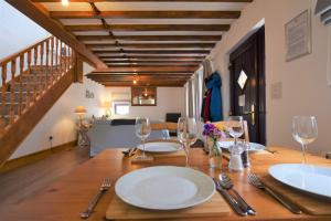 una sala da pranzo con tavolo in legno e bicchieri da vino di Byre Cottage, Lympstone - near Exmouth and Exeter a Exmouth