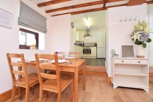 una cucina e una sala da pranzo con tavolo e sedie in legno di Byre Cottage, Lympstone - near Exmouth and Exeter a Exmouth Altre 25 foto