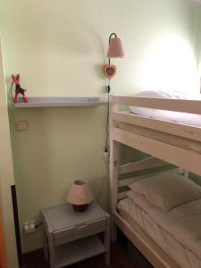フォン・ロムー・オデイヨ・ヴィアにあるLes Cabrisのベッドルーム1室(二段ベッド1組、ランプ、テーブル付)