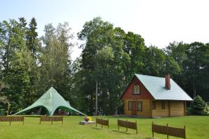 una tenda in un campo vicino a una casa di Holiday Home Dālderi a Bīriņi