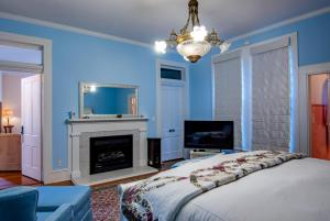 1 dormitorio azul con 1 cama y chimenea en Tolley House, en Lynchburg