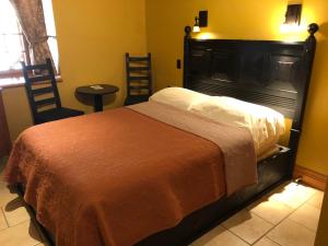 Marieville的住宿－藍舍莊園酒店，一间卧室配有一张大床和一把椅子