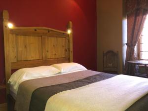 a bedroom with a large bed with a wooden headboard at Manoir Ramezay in Marieville