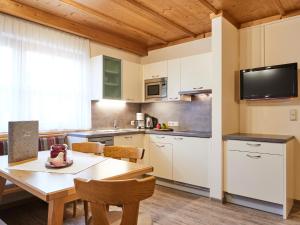 uma cozinha com armários brancos e uma mesa de madeira em Haus Lenz em Serfaus