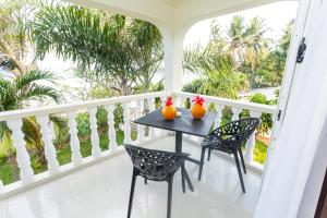馬埃島的住宿－Villa Bella，阳台上的桌子上摆放着两把南瓜