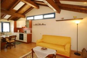 a living room with a yellow couch and a table at Komote in San Zeno