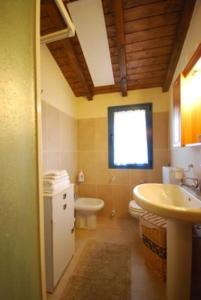 a bathroom with a sink and a toilet and a window at Komote in San Zeno