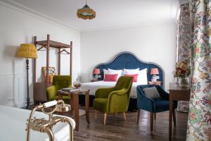um quarto com uma cama com cadeiras verdes e uma mesa em La Maison d'Estournel em Saint-Estèphe