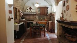 a kitchen with a table and a fireplace at L ORTENSIA in Lucera