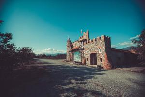 un vecchio edificio in pietra su una strada sterrata di Chateau Bruale a Tkhilistskaro