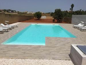 una piscina con tumbonas y una piscina en Villa Vacanze Giuseppe, en Mazara del Vallo