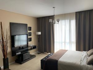Habitación de hotel con cama y TV de pantalla plana. en CONDO NORDELTA - Apart Departamento - COMPLEJO WYNDHAM - BAHIA GRANDE en Tigre