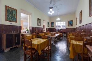 um restaurante com mesas e cadeiras e toalhas de mesa amarelas em Hotel São Paulo em Nova Friburgo