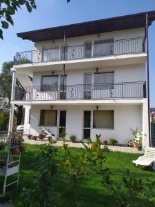 a white building with balconies and a yard at Villa Savovi in Varna City