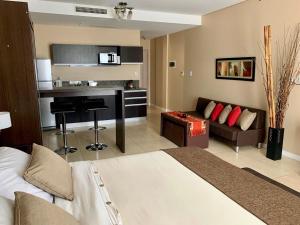 Habitación de hotel con cama y sala de estar. en CONDO NORDELTA - Apart Departamento - COMPLEJO WYNDHAM - BAHIA GRANDE en Tigre