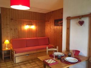 a room with a red bench and a table with plates at Chalet La Licorne au pied des pistes in Notre-Dame-de-Bellecombe