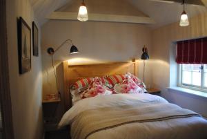 ein Schlafzimmer mit einem Bett, zwei Lampen und einem Fenster in der Unterkunft Courtyard Cottages Lymington, 2 Adults only in Lymington