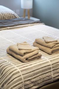 a pile of towels sitting on top of a bed at LocationsTourcoing - Le Carnot in Tourcoing