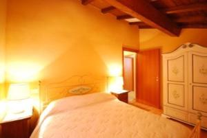 a bedroom with a white bed and two lamps at Komote in San Zeno