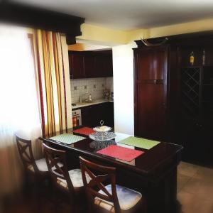 a kitchen with a dining room table with chairs at Penthouse Renașterii Amazonia in Timişoara