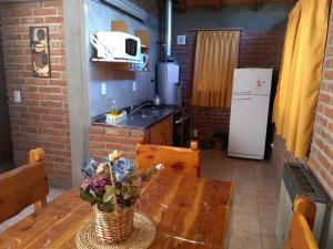a kitchen with a wooden table with a vase of flowers on it at Cabañas del Bosque Bariloche in San Carlos de Bariloche