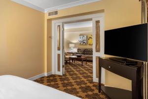 a hotel room with a bed and a flat screen tv at Omni Houston Hotel in Houston