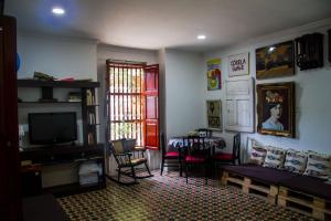 a living room with a television and a table and chairs at Casa San Benito Abad in Cartagena de Indias