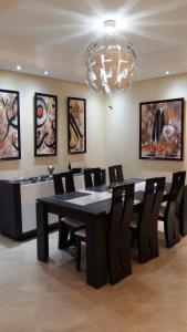 a dining room with a table and chairs and a chandelier at Appartement de luxe in Casablanca