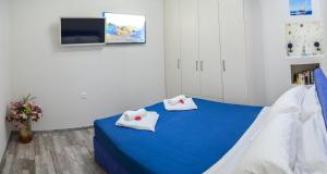 Habitación con cama azul y 2 almohadas blancas. en Epaminontas Captain en Agia Galini
