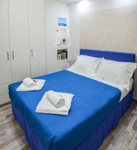 a bedroom with a blue bed with towels on it at Epaminontas Captain in Agia Galini