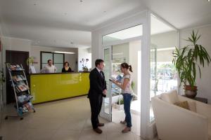 Ein Mann und eine Frau stehen in einer Lobby in der Unterkunft Hotel Marinella in Sanremo