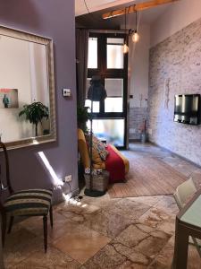een woonkamer met een stoel en een spiegel bij Il loft di Nina in Florence